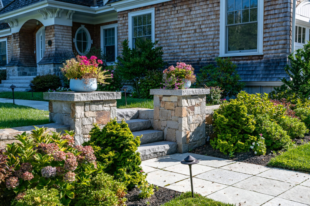 Stone columns with plantings surrounding granite walkway in Cohasset, Massachusetts